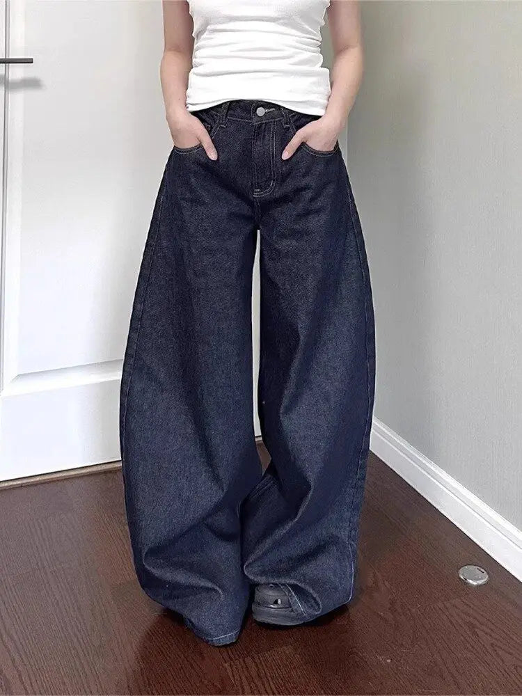 Vaqueros wide leg oversize en índigo, de frente en un pasillo, con la pernera amontonándose en el suelo