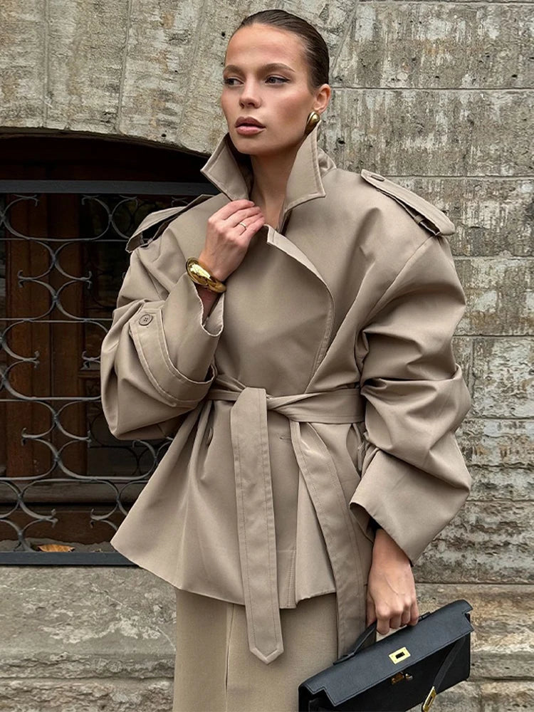 Mujer con el trench corto color piedra ceñido sobre una falda a juego