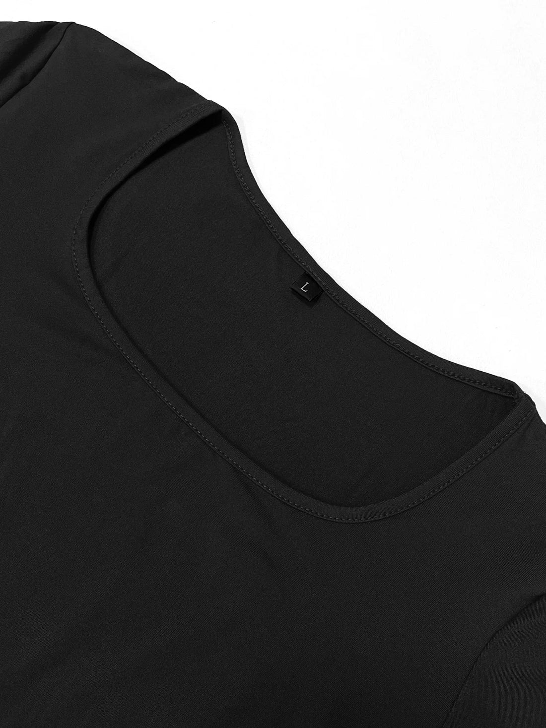 Detalle en plano del escote cuadrado y la manga larga del vestido de canalé negro