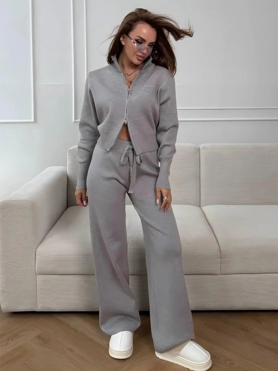 Mujer con el conjunto de punto gris y zapatillas blancas, con el cuello alto y la caída de la pernera ancha