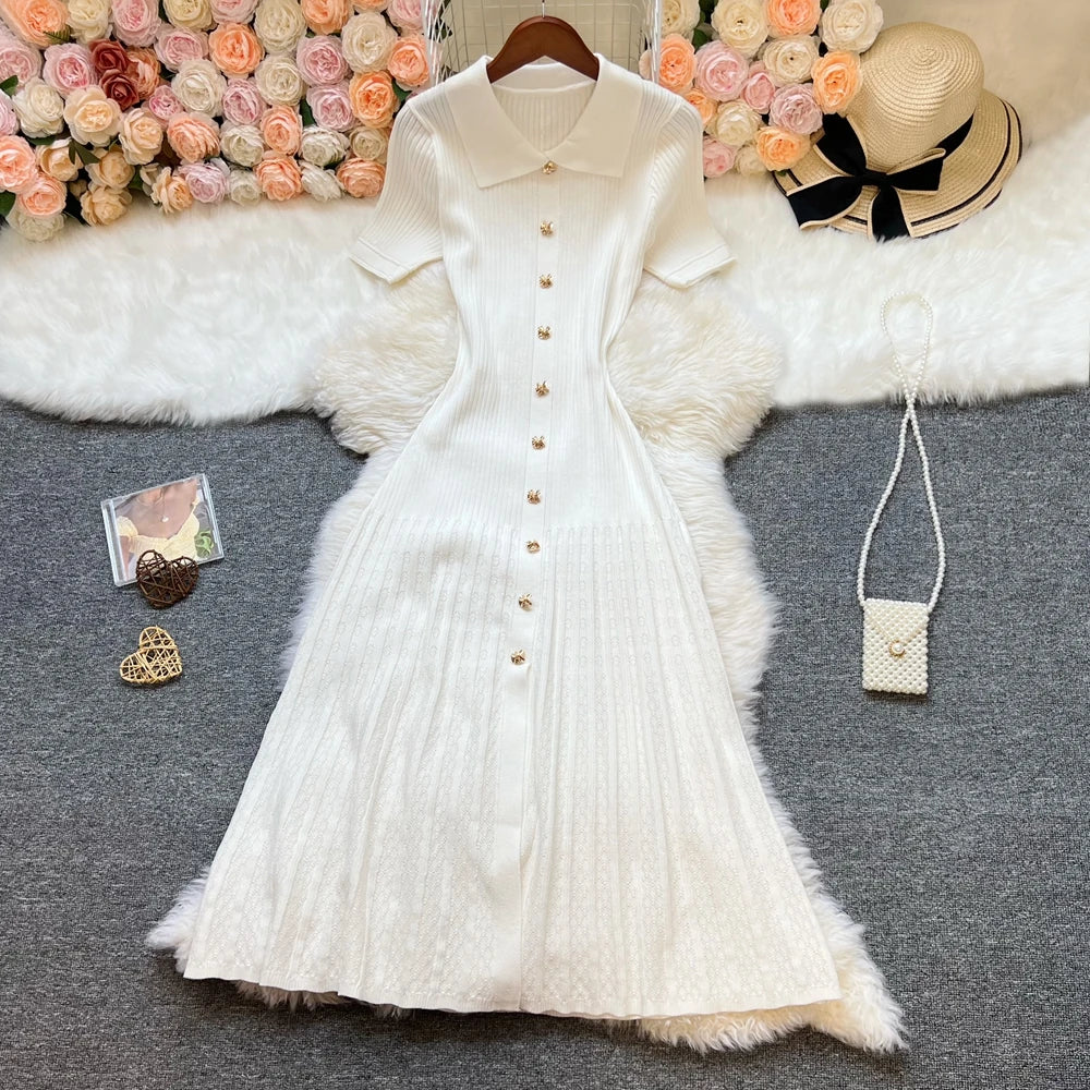 Versión crema del vestido midi de canalé en plano, con los botones abrochados hasta el cuello polo