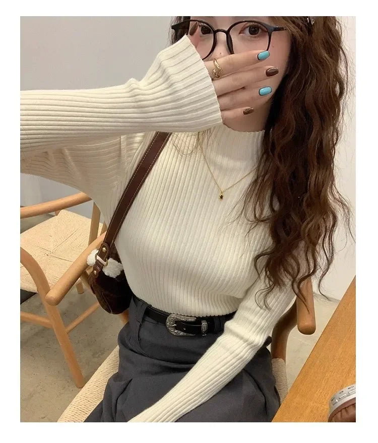 El mismo jersey crema con pantalón gris, con el cuello perkins alto despejado