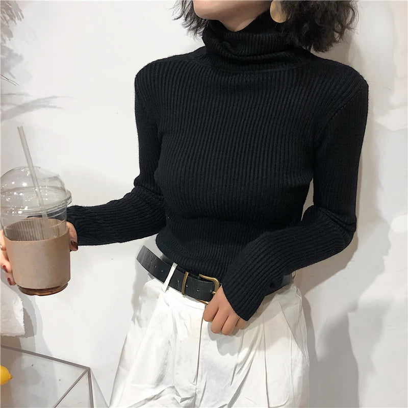 Mujer con el jersey negro de cuello vuelto y pantalón wide leg blanco