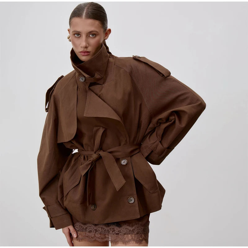 Modelo con el trench oversize chocolate sobre un vestido lencero con encaje, con el hombro caído