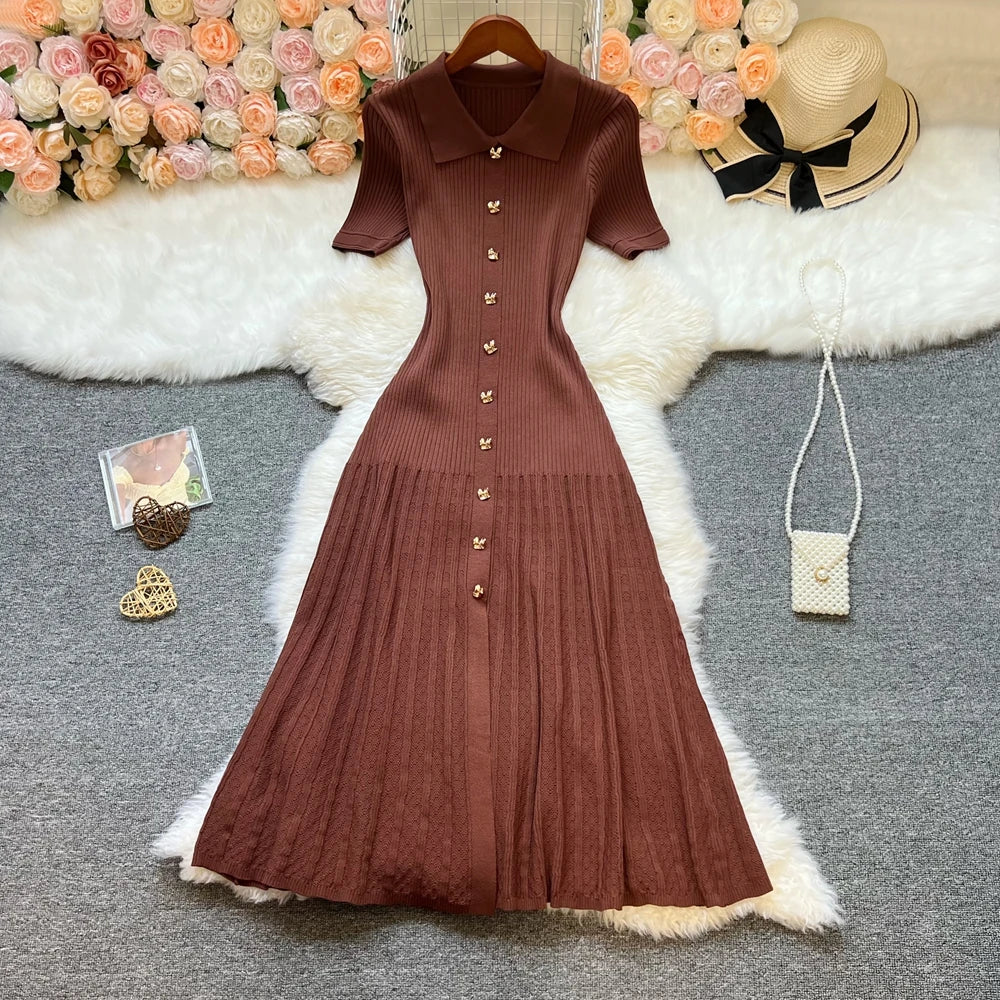 El mismo vestido midi de canalé en chocolate, en plano y con las mangas cortas extendidas