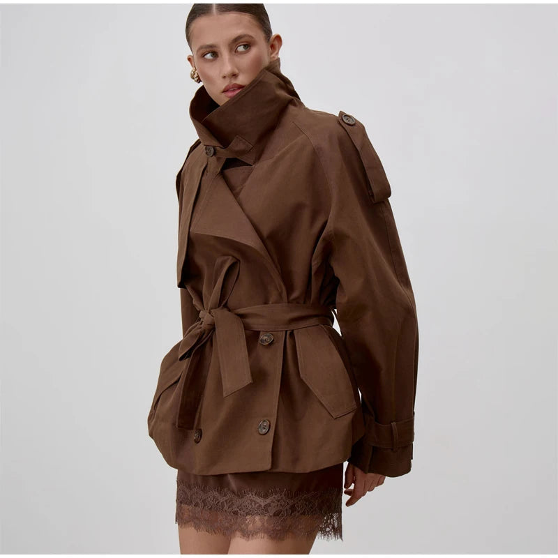 Modelo con el trench oversize chocolate, con las carteras de las solapas y el cinturón anudado